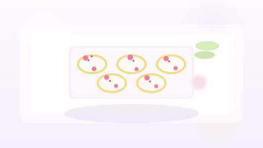 Frozen banana bites with yogurt and pink freeze-dried fruit on a white tray with airy blush styling