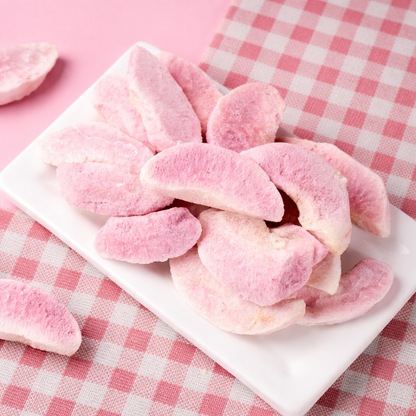 Pink freeze dried peach on a white plate with a pink checkered tablecloth